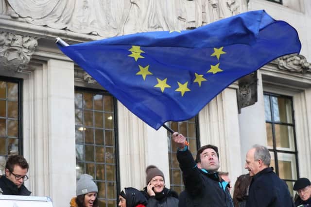 A man waves a flag outside the Supreme Court in London where Britain's most senior judges will rule if Theresa May has the power to trigger the formal process for the UK's exit from the European Union. PRESS ASSOCIATION Photo. Picture date: Tuesday January 24, 2017. Ministers are braced for the Supreme Court to decide that Parliament must be given a vote on starting the divorce proceedings. See PA story POLITICS Brexit. Photo credit should read: Jonathan Brady/PA Wire PPP-170124-104207001
