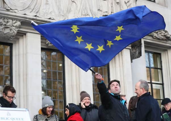 A man waves a flag outside the Supreme Court in London where Britain's most senior judges will rule if Theresa May has the power to trigger the formal process for the UK's exit from the European Union. PRESS ASSOCIATION Photo. Picture date: Tuesday January 24, 2017. Ministers are braced for the Supreme Court to decide that Parliament must be given a vote on starting the divorce proceedings. See PA story POLITICS Brexit. Photo credit should read: Jonathan Brady/PA Wire PPP-170124-104207001