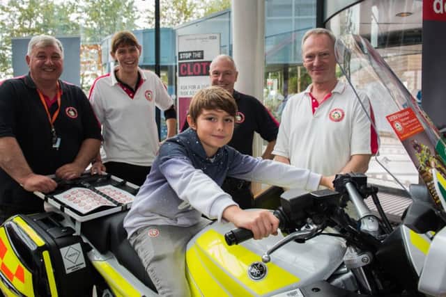 Sidney Swallow astride a motorbike with the SERV Wessex Volunteer Blood Runners Service team 
(171187-359)