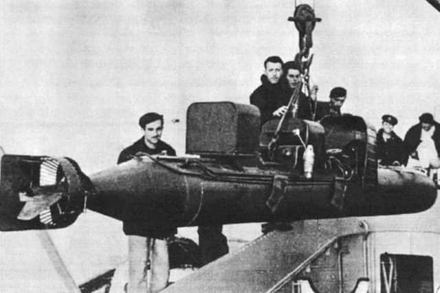 An Italian human torpedo with warhead attached is raised from the hold of an Italian ship.