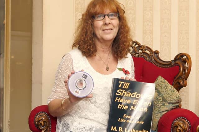Brenda Bickers with the anthology that features her poem