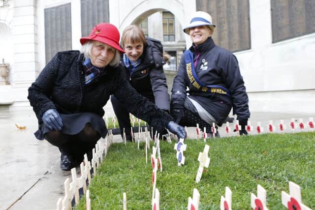 Members of the Association of the Wrens Jan Vanson, Kathryn Simmons and Gail Foster placing crosses in memory of Wrens who losst their lives on HMS Aguila Picture: Habibur Rahman