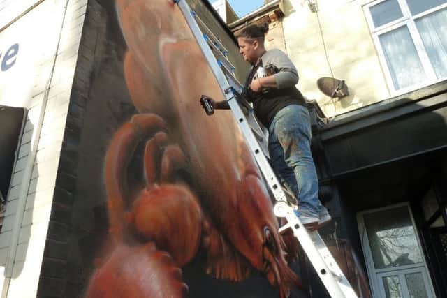 Hayley Garner, one half of street artist duo Nomad Clan, working on the mural at Play Dead studio in Highland Road, Southsea