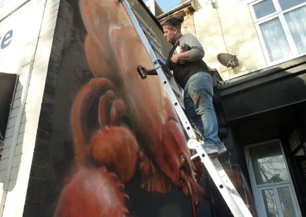 Hayley Garner, one half of street artist duo Nomad Clan, working on the mural at Play Dead studio in Highland Road, Southsea