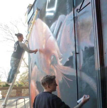 Hayley Garner, on the ladder, and Joy Gilleard, of Nomad Clan working on the mural outside Play Dead studio in Highland Road, Southsea